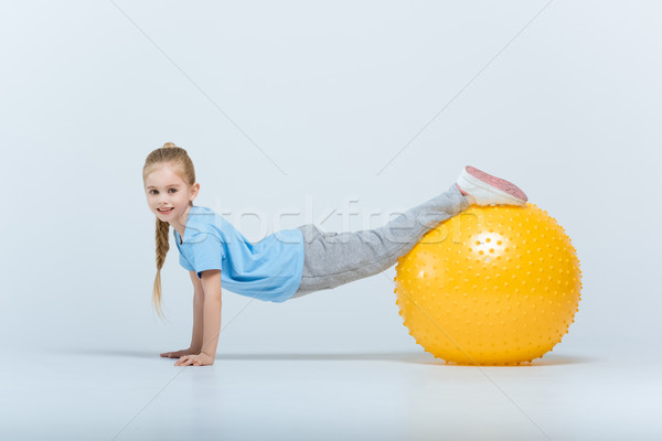 smiling sporty girl exercising with fitness ball on white Stock photo © LightFieldStudios