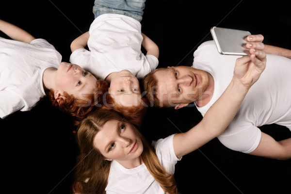 high angle view of family taking selfie on smartphone isolated on black Stock photo © LightFieldStudios