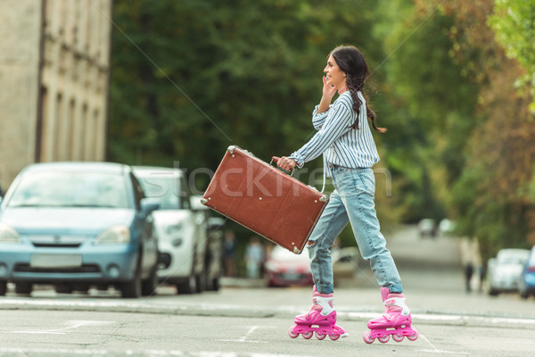 Fille patins valise vue de côté heureux brunette Photo stock © LightFieldStudios