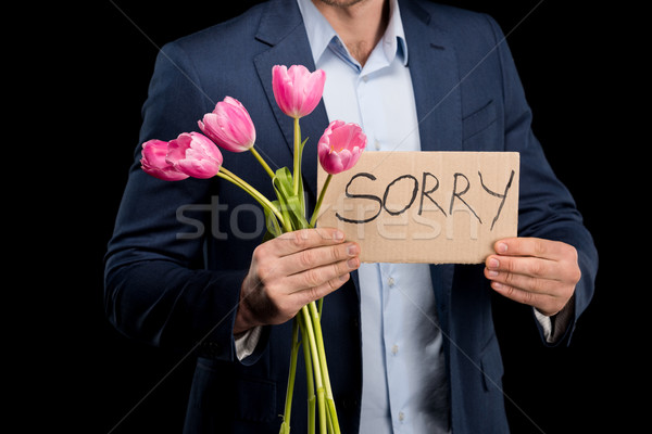 partial view of stylish man holding tulips bouquet and sorry sign on black Stock photo © LightFieldStudios
