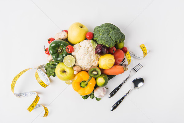 vegetables and fruits laying on white background with fork, spoon and measuring tape   Stock photo © LightFieldStudios