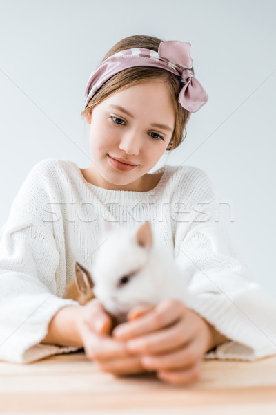 selective focus of smiling girl holding cute furry rabbits on white  Stock photo © LightFieldStudios