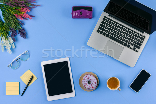 top view of digital devices, flowers, cup of coffee with doughnut and camera on blue   Stock photo © LightFieldStudios