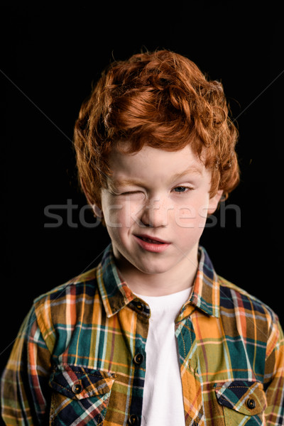 portrait of adorable redhead boy blinking isolated on black Stock photo © LightFieldStudios