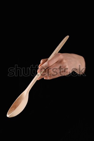 cropped image of woman holding wooden spatula isolated on black Stock photo © LightFieldStudios