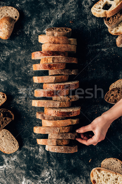 cropped shot of female hand and arranged pieces of bread on dark surface with flour Stock photo © LightFieldStudios