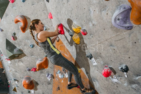 woman climbing wall with grips Stock photo © LightFieldStudios