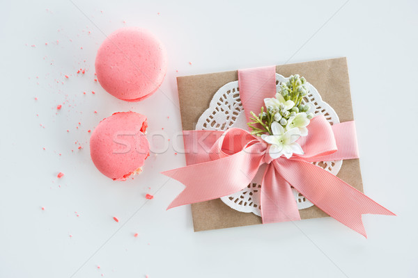 Top view of decorative kraft envelope with bow and pink macarons isolated on white, wedding invitati Stock photo © LightFieldStudios