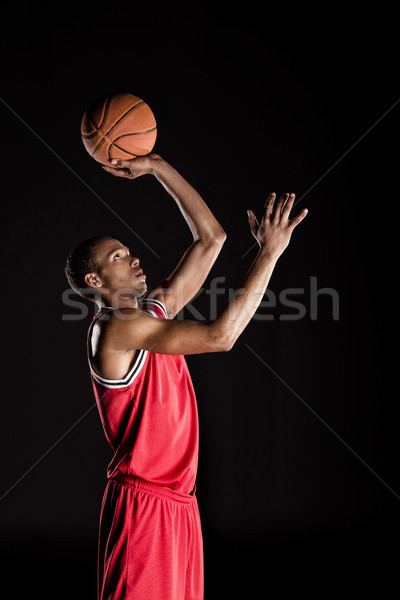 african sporty man in sports uniform playing basketball on black Stock photo © LightFieldStudios