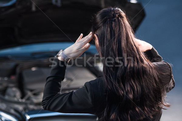 Troubled woman looking at car engine Stock photo © LightFieldStudios