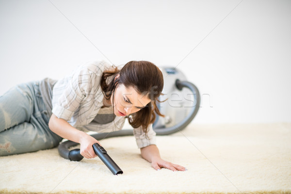 Woman vacuuming carpet Stock photo © LightFieldStudios