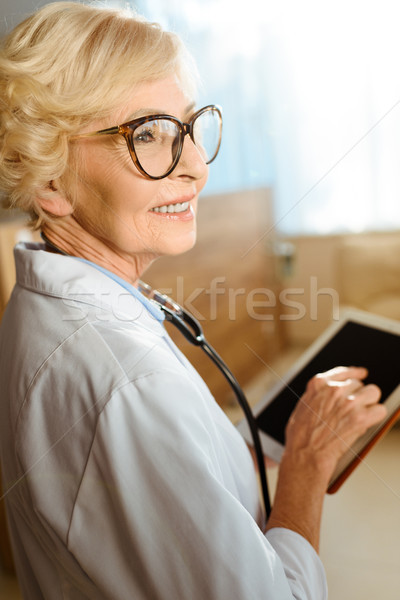Senior médico digital comprimido jaleco óculos Foto stock © LightFieldStudios