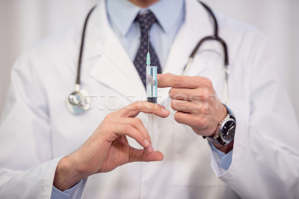 Doctor holding syringe Stock photo © LightFieldStudios