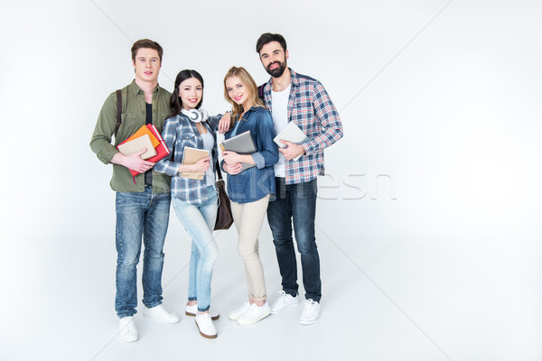 four young students in casual clothes holding books on white Stock photo © LightFieldStudios