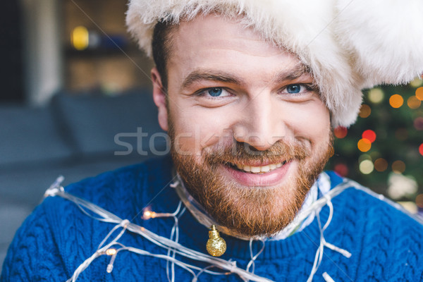man tied up with christmas garland Stock photo © LightFieldStudios