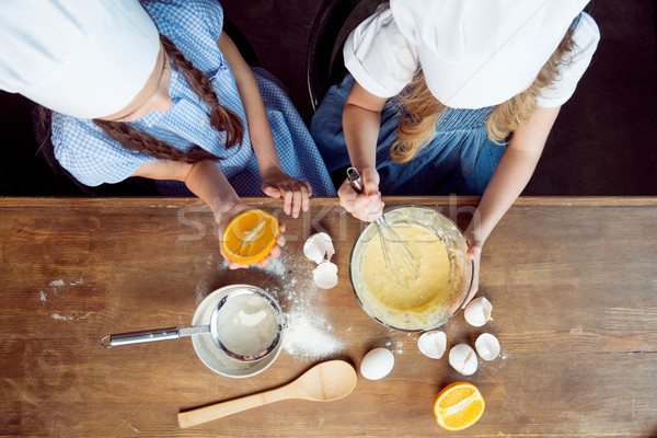 overhead view of girls making dough for cookies on wooden table  Stock photo © LightFieldStudios