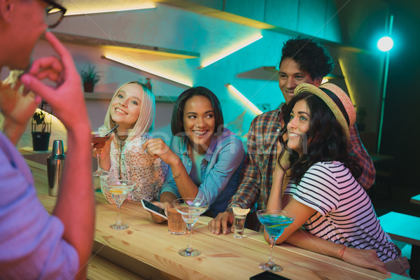 multicultural friends with drinks in bar Stock photo © LightFieldStudios