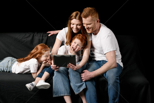 smiling family using digital tablet isolated on black Stock photo © LightFieldStudios