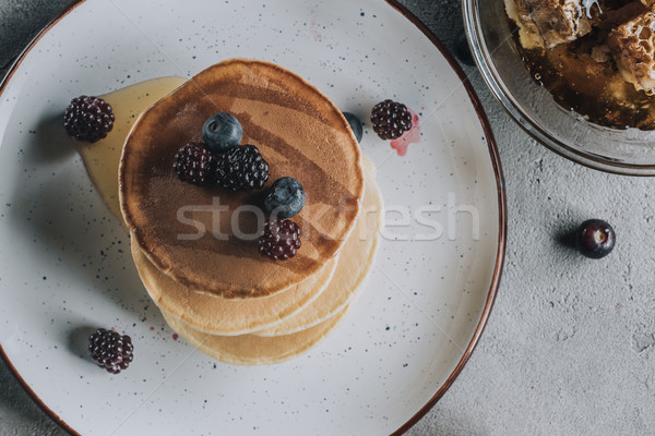 top view of sweet homemade pancakes with fresh berries and honey  Stock photo © LightFieldStudios