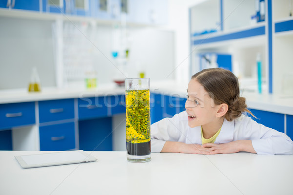 portrait of excited girl scientist looking at experimental tube in lab Stock photo © LightFieldStudios