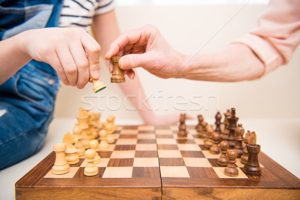Stock photo: Close-up partial view of girl and senior woman playing chess