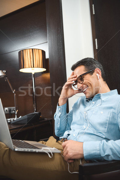 businessman in headphones using laptop Stock photo © LightFieldStudios