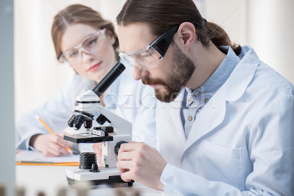 Homem olhando microscópio moço químico trabalhando Foto stock © LightFieldStudios