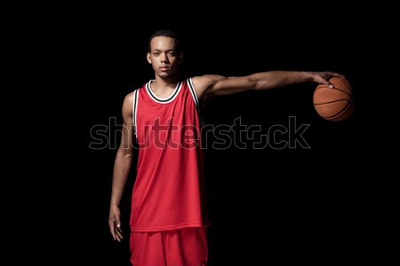 Young athletic man in uniform playing basketball on black   Stock photo © LightFieldStudios