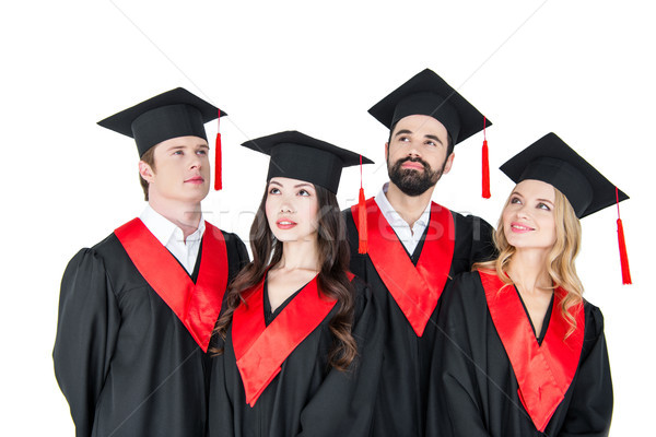 Group of young men and women in graduation caps looking up on white Stock photo © LightFieldStudios