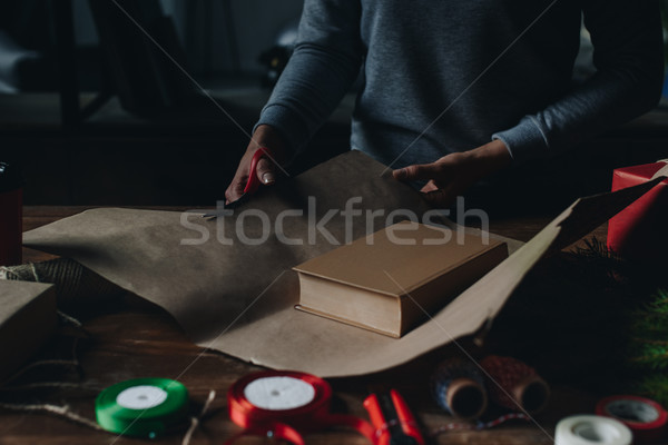 Stock photo: woman wrapping book as christmas gift