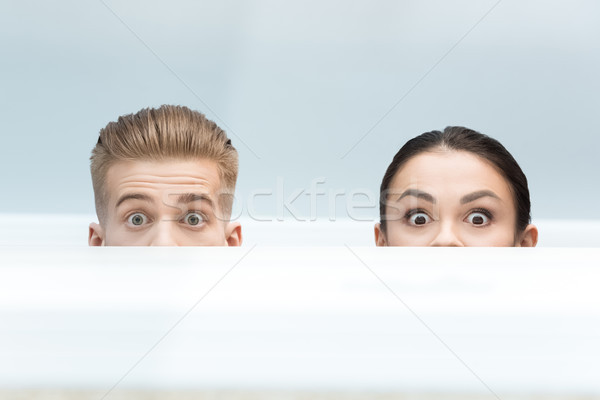 Stock photo: partial view of scared scientists looking out behind table in lab