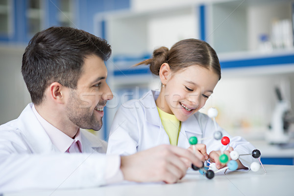 Smiling teacher and student scientists looking at molecule model in lab Stock photo © LightFieldStudios