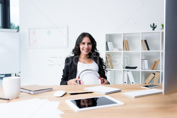 pregnant businesswoman with headphones on tummy Stock photo © LightFieldStudios