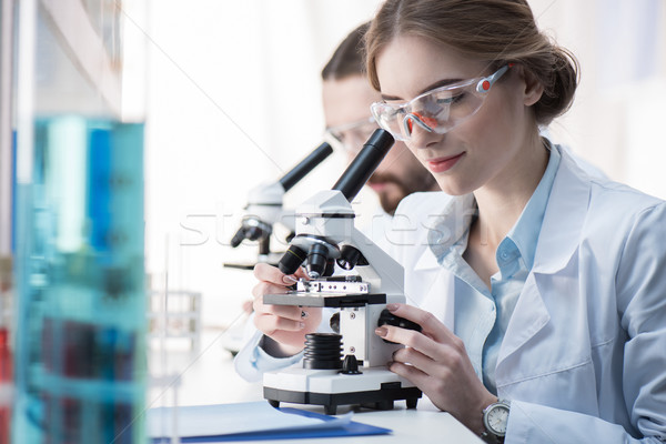 Femeie om de ştiinţă lucru microscop tineri laborator Imagine de stoc © LightFieldStudios