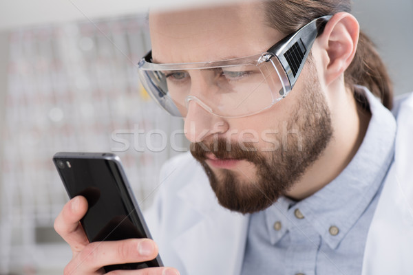 Férfi okostelefon közelkép portré fiatalember szemüveg Stock fotó © LightFieldStudios