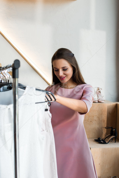 young woman choosing clothes in boutique Stock photo © LightFieldStudios