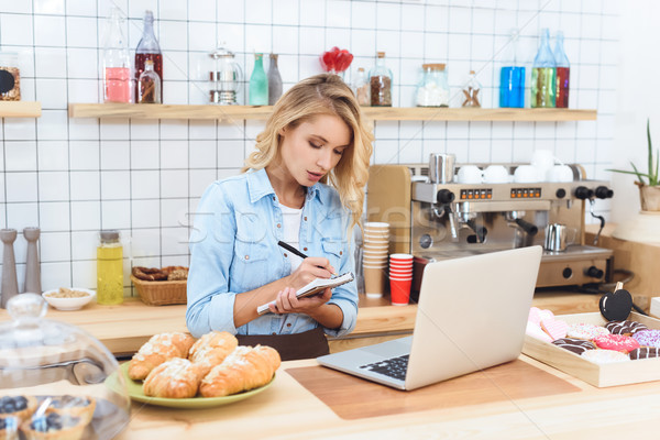 [[stock_photo]]: Café · propriétaire · prendre · des · notes · jeunes · petit · commerce · utilisant · un · ordinateur · portable