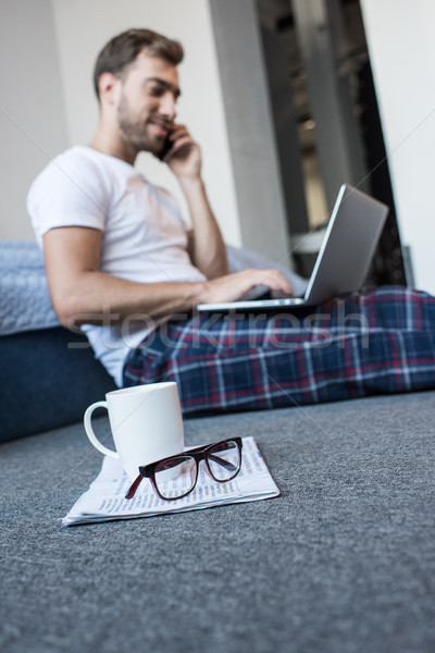 Man on phone using laptop Stock photo © LightFieldStudios