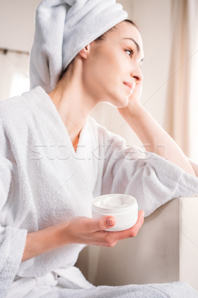 woman in bathrobe holding jar of cream Stock photo © LightFieldStudios