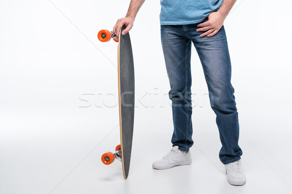 Stock photo: partial view of man standing with skateboard on white