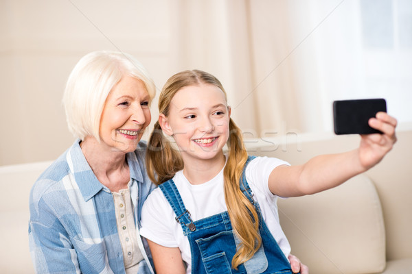 Heureux grand-mère petite fille séance ensemble canapé [[stock_photo]] © LightFieldStudios