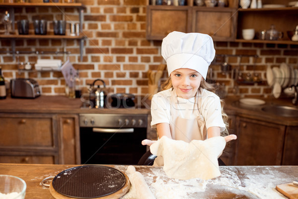 little girl making pizza dough on wooden tabletop in kitchen  Stock photo © LightFieldStudios