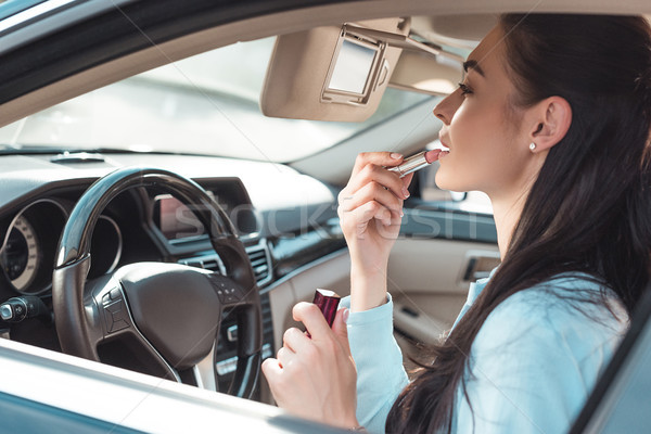 woman applying lipstick in car Stock photo © LightFieldStudios