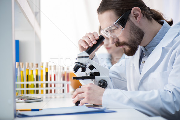 Uomo guardando microscopio giovane chimico occhiali Foto d'archivio © LightFieldStudios
