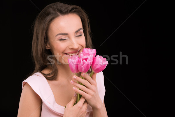 Happy young woman with closed eyes holding beautiful tulips on black, international womens day conce Stock photo © LightFieldStudios