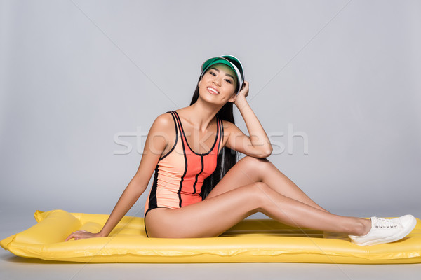 Femeie costum de baie şedinţei piscină saltea shot Imagine de stoc © LightFieldStudios