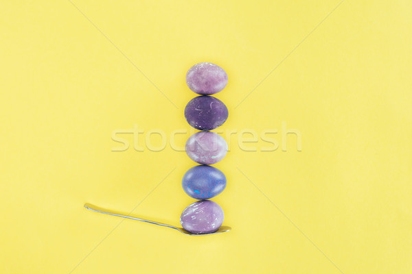 top view of shabby easter eggs in row on spoon, isolated on yellow Stock photo © LightFieldStudios