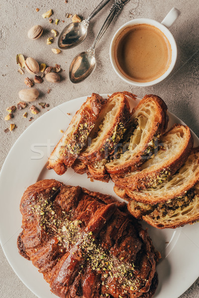 flat lay with cup of coffee and sweet pastry on plate on light tabletop Stock photo © LightFieldStudios