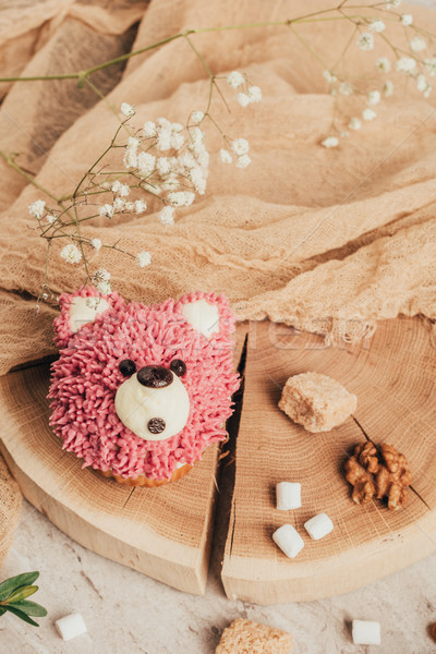top view of sweet pink muffin in shape of bear and nuts with sugar on wooden board Stock photo © LightFieldStudios