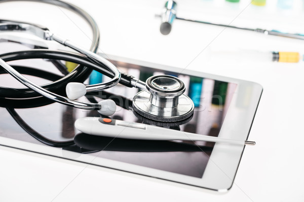 close up view of stethoscope and thermometer on digital tablet on white  Stock photo © LightFieldStudios